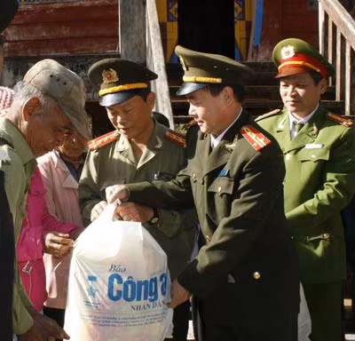 Đại tá Trần Kim Thẩm, Phó Tổng biên tập Báo CAND trao quà cho đồng bào nghèo ở Gia Lai.