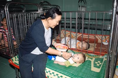 Má Mười đang chăm sóc những đứa con tật nguyền.