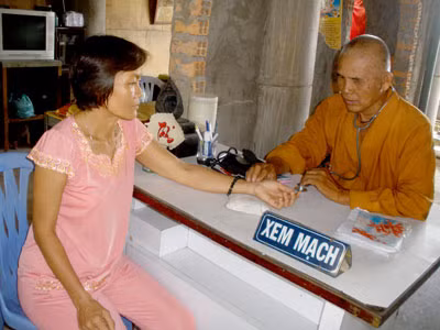 Sư ông Thích Minh Quang đang khám bệnh cho một bệnh nhân nghèo.