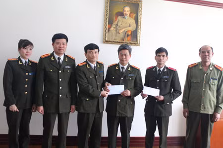 Đại tá Nguyễn Phúc Bồng, Trưởng ban Pháp luật - Bạn đọc Báo CAND trao 50 triệu đồng ủng hộ cho 2 gia đình cán bộ Công an tỉnh Quảng Ninh có hoàn cảnh khó khăn.