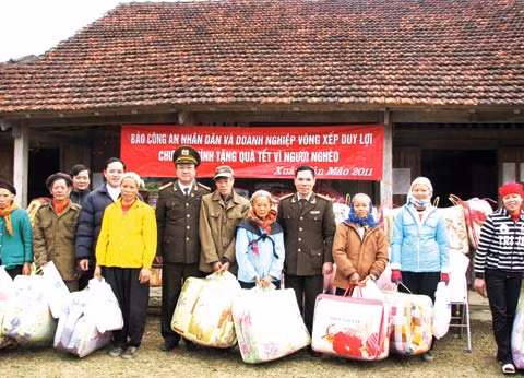 Đại tá, nhà thơ Hồng Thanh Quang, Phó Tổng Biên tập Báo CAND và đại diện Doanh nghiệp Võng xếp Duy Lợi cùng Công an tỉnh Cao Bằng trao quà tết cho bà con nghèo xã Mai Long.