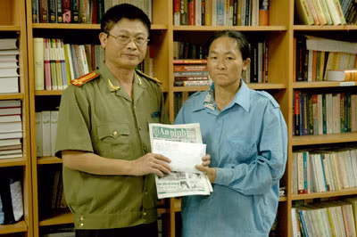 Thượng tá Phạm Văn Ba, Trưởng ban Chuyên đề ANTG trao tặng tiền do bạn đọc ủng hộ cho bà Đặng Thị Hòa.