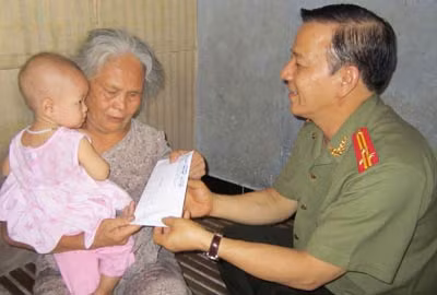 Đại diện Báo CAND trao số tiền 10 triệu đồng của bạn đọc tặng bé Kiều Trang.