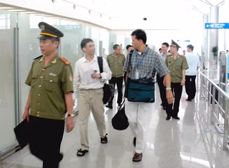 Nguyễn Quốc Quân (người mặc áo sơmi trắng dài tay) khi bị trục xuất khỏi Việt Nam năm 2008.