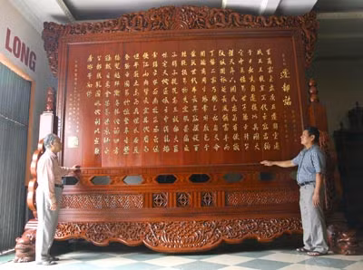 Ông Thế Long và ông Vũ Quý, Giám đốc Công ty Đồ gỗ Hưng Long trước công trình “Chiếu dời đô” đã cơ bản hoàn thiện.