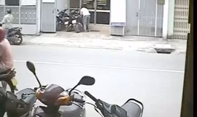 Một tên tội phạm (áo trắng) đang lấy trộm chiếc SH (ảnh chụp từ camera an ninh).