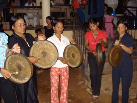 Các thành viên gia đình cô gái chuẩn bị vỗ chiêng chúc mừng đôi tân nương.