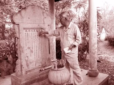 Ông Thế đang giải nghĩa các chữ Hán khắc trên bia di chúc của cụ Phan.