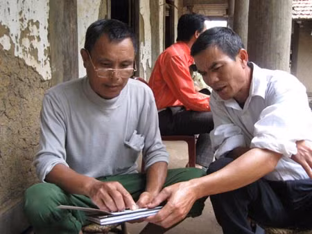 Trưởng bản Lường Chí Cu đang xem lại danh sách thống kê những người bị HIV/AIDS.