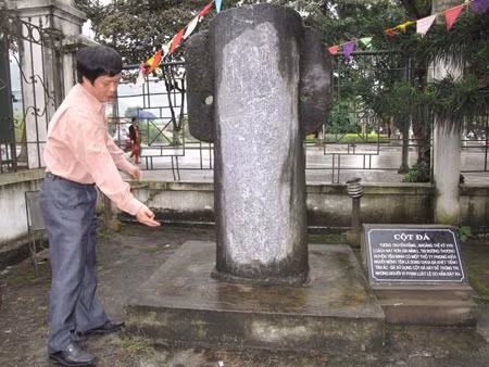 Ông Vũ Văn Hợp đang kể cho chúng tôi về cột đá treo người.