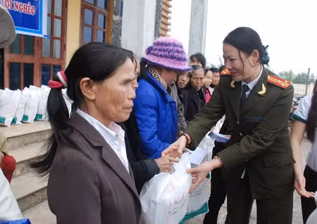 Thượng tá Nguyễn Thị Triều, Chủ tịch Hội Phụ nữ Công an tỉnh Quảng Bình tặng quà người nghèo xã Ngư Thủy Bắc.