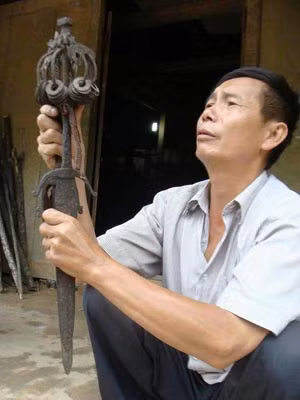 Phàn Tà Phâu kính ngưỡng nhìn đôi kiếm cổ, bảo vật của tổ tiên.