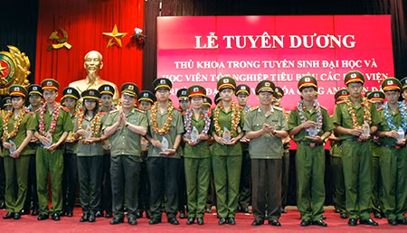 Trung tướng Bùi Quang Bền, Ủy viên TW Đảng, Thứ trưởng Bộ Công an; Trung tướng Trần Bá Thiều, Tổng cục trưởng Tổng cục XDLL CAND cùng lãnh đạo các học viện, trường CAND chụp ảnh lưu niệm với 42 thủ khoa, học viên tiêu biểu.