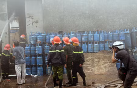 Người dân và lực lượng chữa cháy đang vận chuyển hàng hóa khỏi đám cháy.