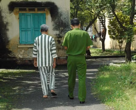 Ông Phạm Văn Phê lê bước chân chậm chạp về buồng giam.