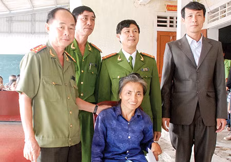 Đại tá Trần Kim Thẩm, Phó Tổng Biên tập Báo CAND và Đại tá Đặng Hoài Sơn, Trưởng Công an huyện Kỳ Anh thăm hỏi, động viên bà Lê Thị Tỵ. (Ảnh: Nguyễn Hưng)