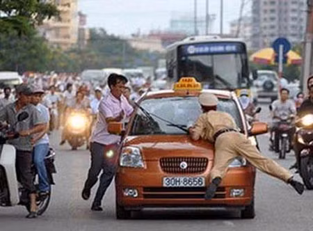 Một vụ chống người thi hành công vụ: Lái xe hất CSGT lên capo taxi.
