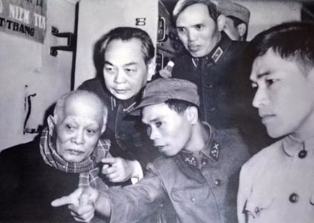 Tiểu đoàn trưởng Đinh Thế Văn (đội mũ ở giữa) đang thuyết minh với Chủ tịch Tôn Đức Thắng (ngoài cùng bên trái) và Đại tướng Võ Nguyên Giáp ngay sau khi bom vừa dứt. Ảnh tư liệu gia đình ông Đinh Thế Văn.
