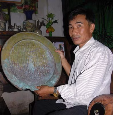 Anh Lợi bên chiếc mâm đồng ghi bản sao mộ chí.