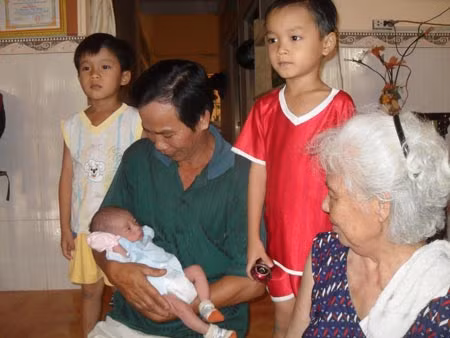 Mẹ con anh Út Bông và những đứa trẻ họ nhận nuôi.