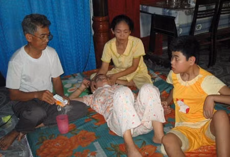 Vợ chồng anh Địu chăm sóc 2 đứa con bị chất độc da cam còn lại.