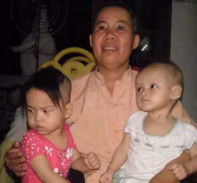 Bé Hoa Quỳnh (bìa phải) với chứng bệnh úng não và giãn cơ tim cần được mọi tấm lòng gần xa hỗ trợ chữa trị.