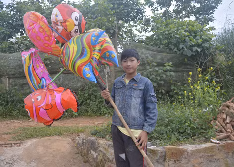 Nhờ đôi mắt xanh, Hào đi bán bong bóng khá đắt hàng.