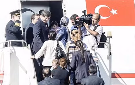 Thủ tướng Thổ Nhĩ Kỳ Ahmet Davutoglu (trái) vào máy bay với các con tin ngày 20/9/2014, tại sân bay ở thành phố Sanliurfa, miền nam Thổ Nhĩ Kỳ, gần biên giới Syria.