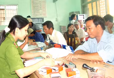 Cán bộ Công an đang tận tình hướng dẫn người dân làm thủ tục đăng ký hộ khẩu thường trú.