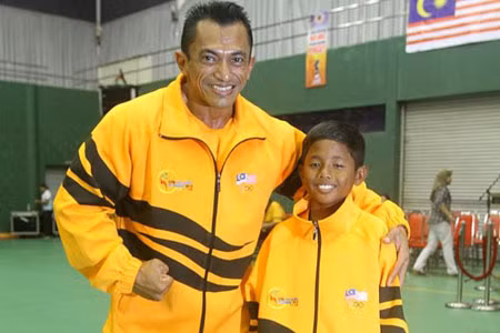 Vận động viên nhỏ nhất SEA Games, Mohd Fauzi Kaman Shah bên cạnh huấn luyện viên của em.