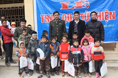 Đại tá Hà Văn Thể, Trung tá Lương Hoàng Vịnh (Phó trưởng Phòng PX 15 Công an tỉnh Tuyên Quang) và anh Trần Văn Tuấn, Giám đốc Công ty Hùng Đức trao quà cho các cháu học sinh xóm Dùm, phường Nông Tiến.