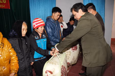 Đại tá Hà Văn Thể, Trưởng Ban KT - VH - XH, Báo CAND trao những chiếc chăn, giúp bà con đón một mùa xuân thêm ấm áp.