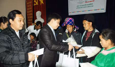 Bà con các bản thuộc xã San Sả Hồ nhận quà của đại diện nhà tài trợ.