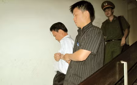 Dẫn giải đối tượng Nguyễn Tuấn Anh (áo trắng) về Trại tạm giam Hà Nội.