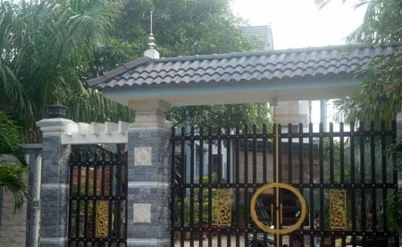 Phía sau cánh cổng và hàng cau là căn biệt thự lớn của bà Hoa.