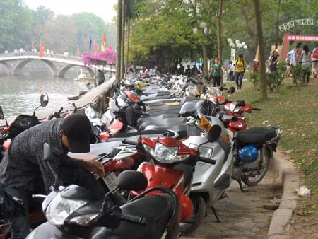 Quá tải, bãi gửi xe tràn cả ra ven hồ, thu giá 10.000đ/xe (ảnh chụp sáng 29/4 tại Công viên Thủ Lệ).