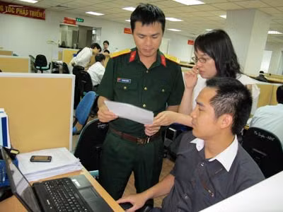 Thiếu tá Tào Đức Thắng trao đổi công tác cùng các đồng nghiệp.