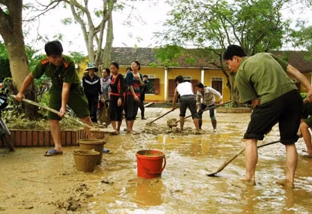 Công an huyện Hương Khê giúp Trường Tiểu học Đông Hải, xã Gia Phố thu dọn bùn đất. Ảnh: Hồng Phú.