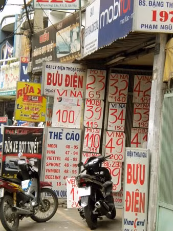 Đại lý bưu điện quảng bá cạnh tranh giá bán và khuyến mãi thẻ cào tại vỉa hè.