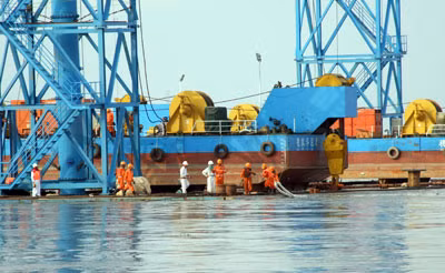 Các Kỹ sư đang móc những sợi cáp kéo vào tàu kéo.