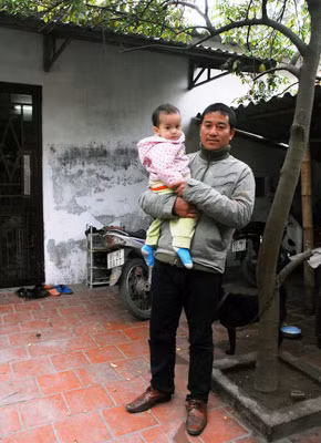 Hai cha con anh Cường bên căn nhà nhỏ.