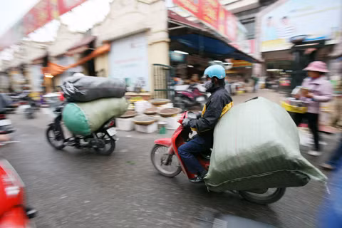 Những chiếc xe máy chở hàng cồng kềnh đang luồn lách trên phố Nguyễn Thiện Thuật (sau lưng chợ Đồng Xuân).