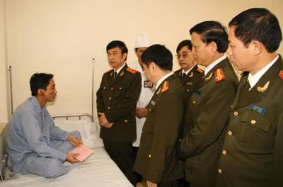 Trung tướng Đặng Văn Hiếu, Ủy viên TW Đảng, Thứ trưởng Bộ Công an thăm hỏi, động viên Trung úy Bùi Trung Dũng (Công an tỉnh Hòa Bình) bị thương trong khi truy bắt tội phạm ma túy (tháng 2/2010). Ảnh: Duy Hiển.