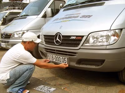 Anh Nguyễn Văn Khanh thích thú gắn BKS 5 số lên chiếc xe mới.