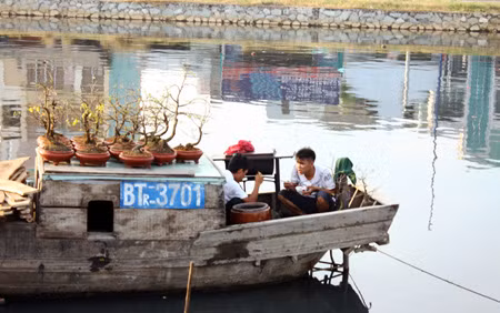 Cách đó không xa, anh Bình và anh Tâm (Bến Tre) đang tận dụng thời gian rảnh rỗi ăn bữa cơm chiều để lót dạ chuẩn bị bán hoa vào ban đêm.
