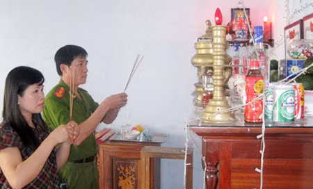 2 anh em Phan Thanh Sương và Phan Thị Di thắp nhang trước bàn thờ cha mẹ.