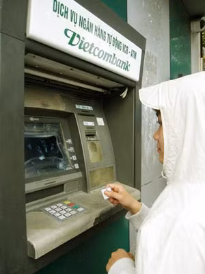 Sinh viên Hoàng Thị Thủy dùng miếng nhựa để bấm nút trên máy ATM.