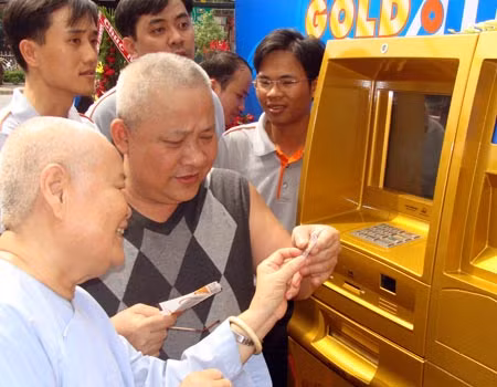 Người dân thích thú khi rút được miếng vàng từ máy ATM. Ảnh: VNE.