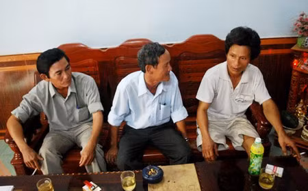 Anh Trần Liệu (phải) đang trình bày với lãnh đạo địa phương về tình trạng các nhóm giang hồ đến nhà “xin đểu”.