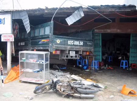 Hiện trường vụ tai nạn với mảng tường của quán cơm bị đổ sụp, bàn ghế hư hỏng nặng do những cú tông liên tiếp của xe tải điên do tài xế Huỳnh An điều khiển.